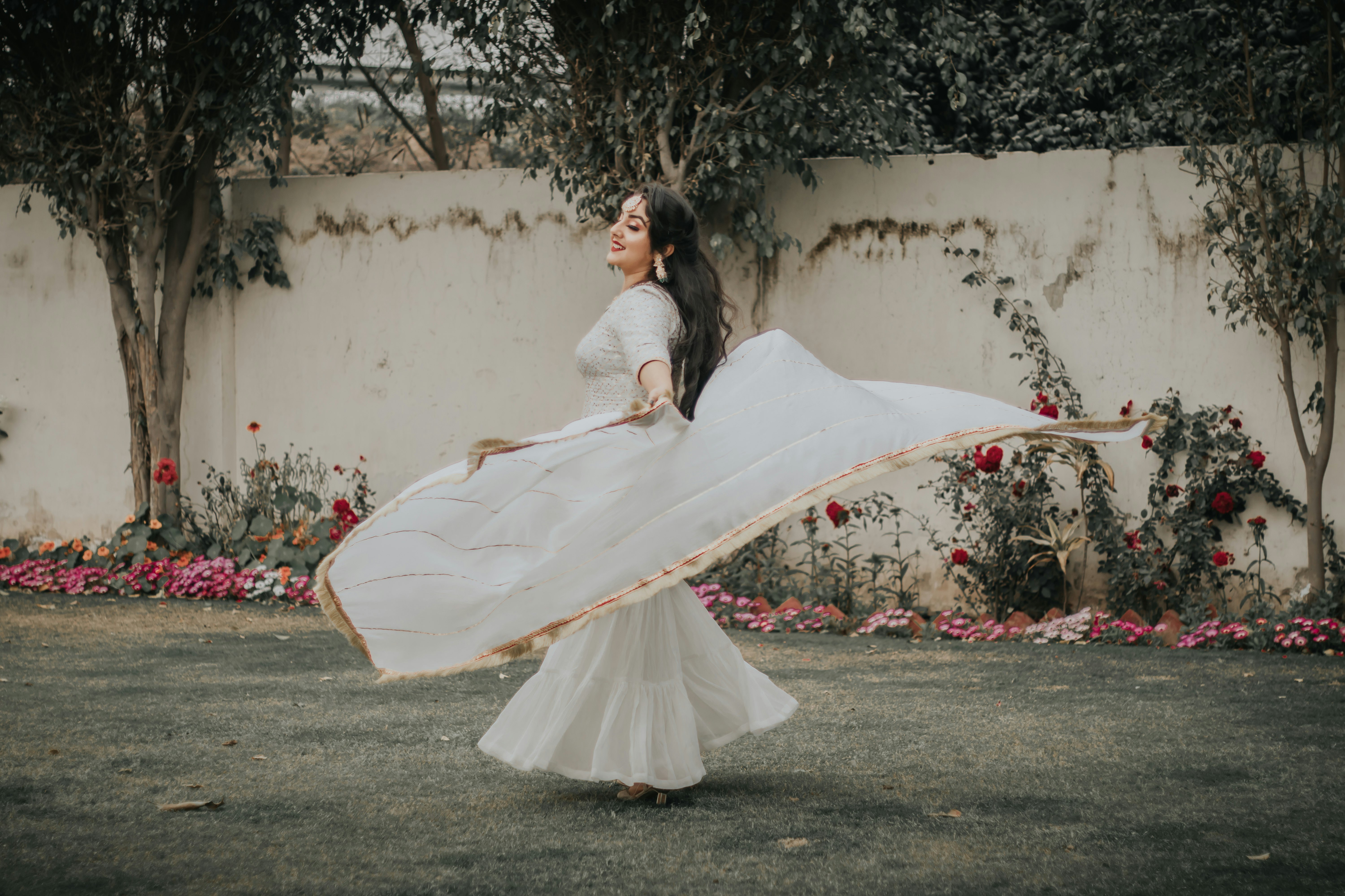 woman in white dress holding white textile